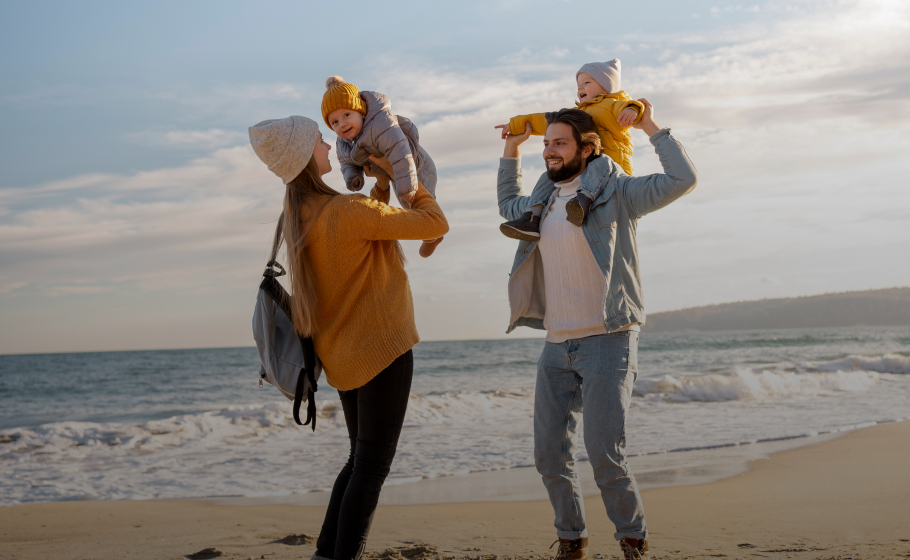 Family enjoying time on the beach with young children